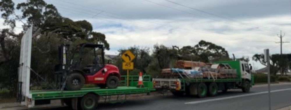 Flatbed-Truck-loaded-with-scaffold-whilst-towing-forklift-on-a-trailer-2-1.jpg